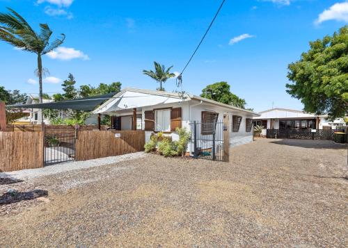 a house with a fence and a gravel driveway at Vila Paus Satu - Ocean Views Hervey Bay in Hervey Bay