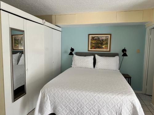 a bedroom with a white bed and a blue wall at Beryls Montego Bay in Montego Bay