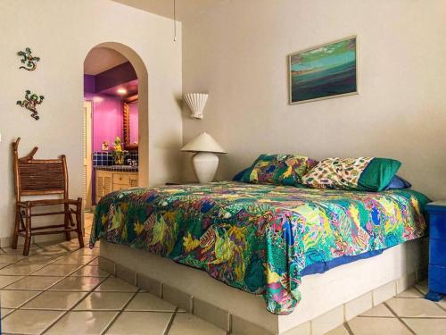Un dormitorio con una cama con un edredón colorido. en Condominio Estilo Mexicano en la playa, en La Paz