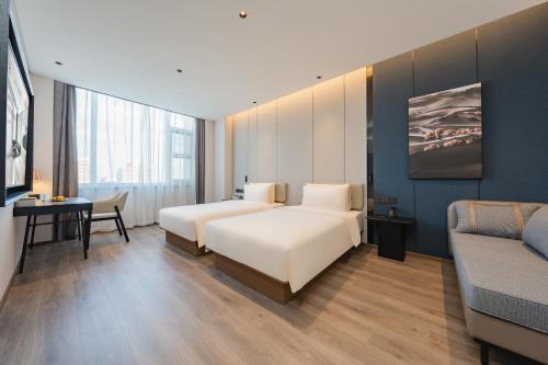 a hotel room with two beds and a desk at Atour Hotel Jiading Nanxiang in Jiading
