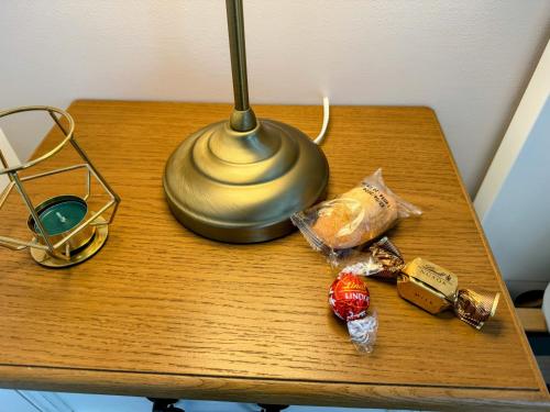 d'une table avec une lampe et de la nourriture. dans l'établissement Studio Hôtel - Lit King Size - Parking - Wifi, à Villemomble