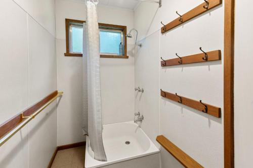 a bathroom with a shower and a toilet and a sink at Basecamp Sawmill in Mount Buller