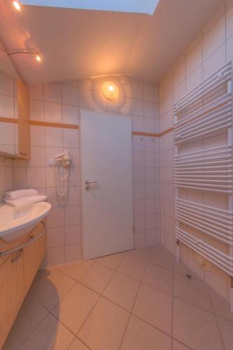 a bathroom with a white door and a sink at Eisvogel Classic 304 in Granzow