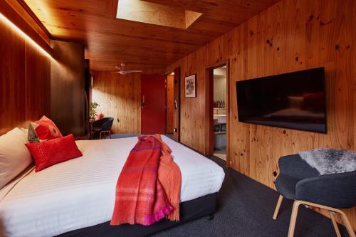 a bedroom with a large bed and a tv on the wall at Iron Creek Bay Estate in Sorell