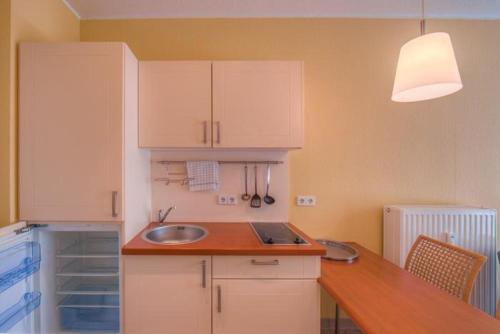 a kitchen with white cabinets and a sink at Strandläufer 111 in Granzow
