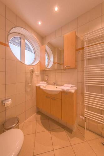 a bathroom with a sink and a toilet and a window at Strandläufer 114 in Granzow