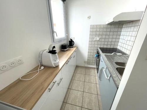 eine weiße Küche mit einem Waschbecken und einem Fenster in der Unterkunft Maison La Tranche-sur-Mer, 2 pièces, 4 personnes - FR-1-22-256 in La Tranche-sur-Mer