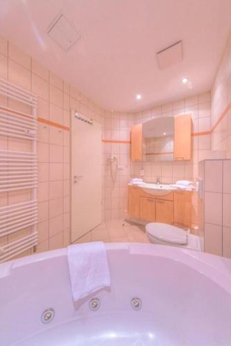 a bathroom with a tub and a toilet and a sink at Strandläufer Classic 101 in Granzow