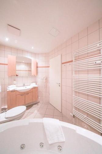 a bathroom with a tub and a toilet and a sink at Strandläufer Classic 102 in Granzow