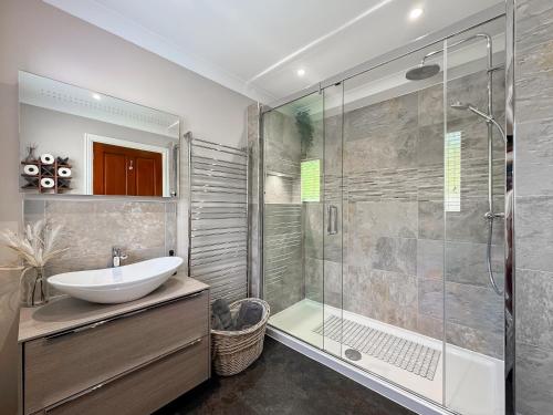a bathroom with a sink and a glass shower at Highbury House in Camborne