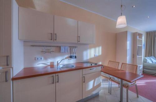 - une cuisine avec un évier et une table dans une chambre dans l'établissement Strandläufer Classic 103, à Granzow