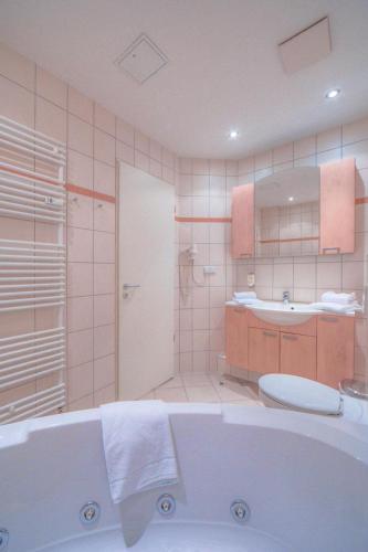 La salle de bains est pourvue d'une baignoire, de toilettes et d'un lavabo. dans l'établissement Strandläufer Classic 103, à Granzow