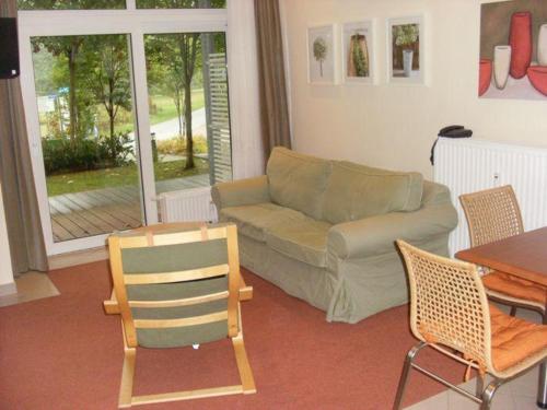 - un salon avec un canapé, une table et des chaises dans l'établissement Strandläufer Classic 106, à Granzow