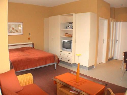 a bedroom with a bed and a tv on a cabinet at Strandläufer Classic 105 in Granzow