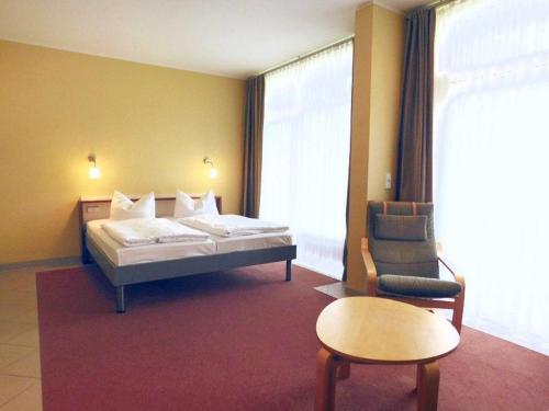 a hotel room with a bed and a chair at Strandläufer Classic 108 in Granzow