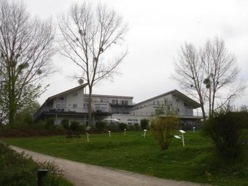 a large white building in a field with trees at Strandläufer Classic 212 in Granzow