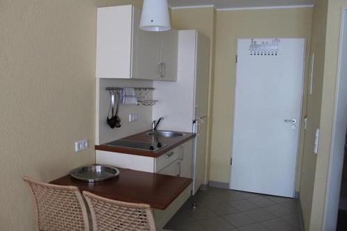 a kitchen with a sink and a table with chairs at Strandläufer Classic 212 in Granzow