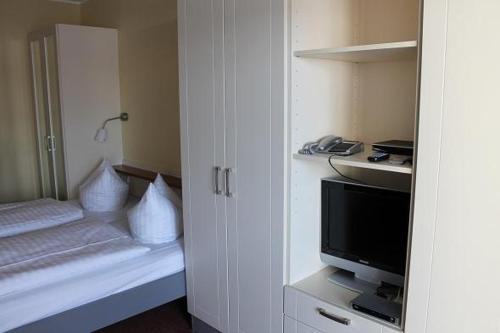 a small room with a tv and a white cabinet at Strandläufer Classic 212 in Granzow