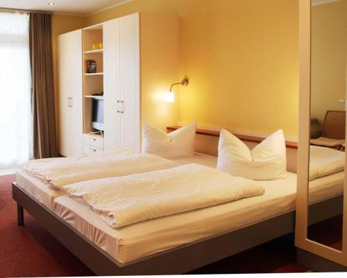 a bedroom with a bed with white sheets and pillows at Strandläufer Classic 215 in Granzow