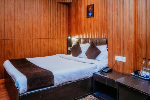 een slaapkamer met een bed en een houten muur bij Hotel Siddhi Vinayak Regency, Mg Marg in Gangtok
