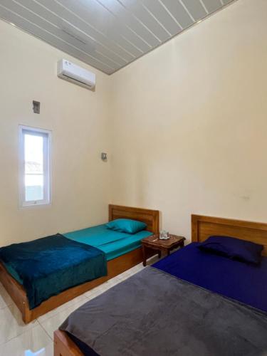 um quarto com 2 camas e uma janela em KBI Hostel em Ternate