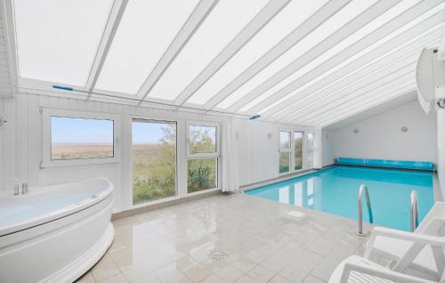 HavrvigにあるNice Home In Hvide Sande With Saunaのバスルーム(バスタブ、スイミングプール付)