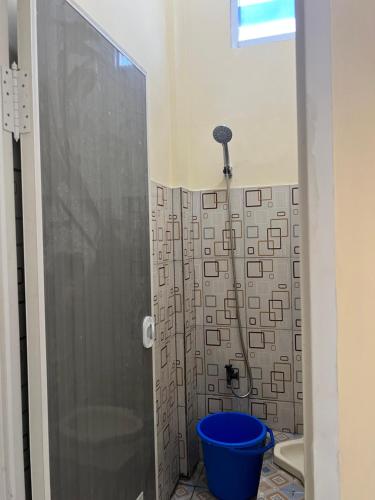 y baño con ducha y cubo azul. en KBI Hostel, en Ternate