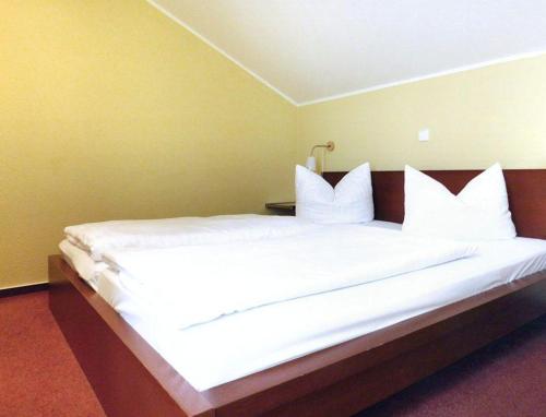 a large bed with white sheets and pillows at Schneeeule 204 in Granzow