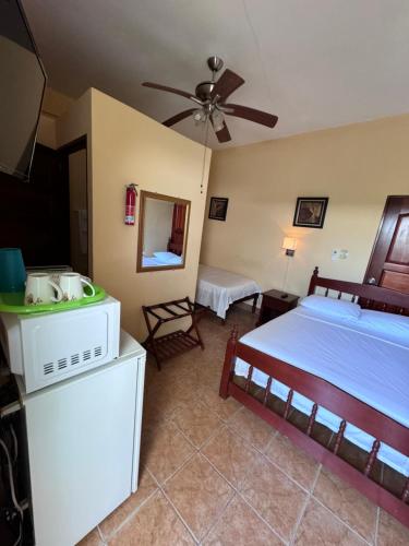een slaapkamer met een bed en een plafondventilator bij Panchos Villas in Caye Caulker