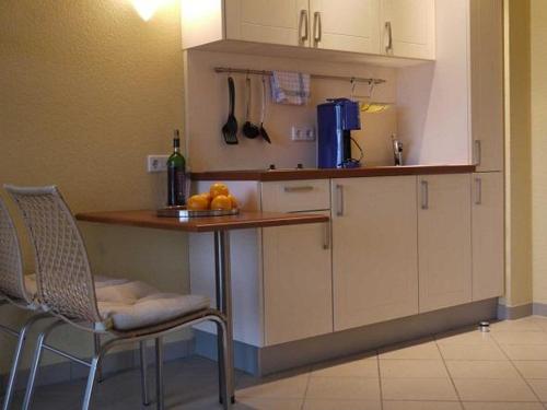 a kitchen with a counter and a table and chairs at Schneeeule 218 in Granzow