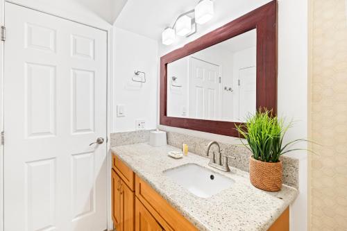 a bathroom with a sink and a mirror at Waikiki Banyan T1-3204 in Honolulu