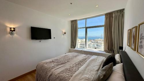 a bedroom with a bed and a large window at hilton apartement families in Tangier