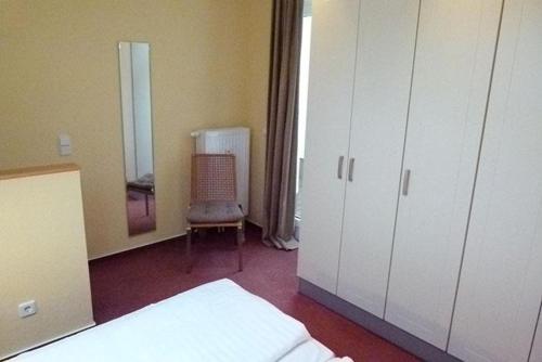 a bedroom with a bed and a chair and a mirror at Schneeeule 222 in Granzow