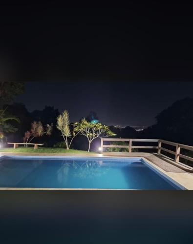 a swimming pool at night with a fence and trees at Sítio Paraiso in Rio de Janeiro