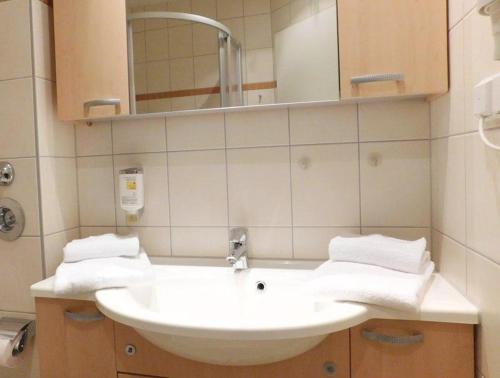 a bathroom with a white sink and a mirror at Schneeeule 223 in Granzow