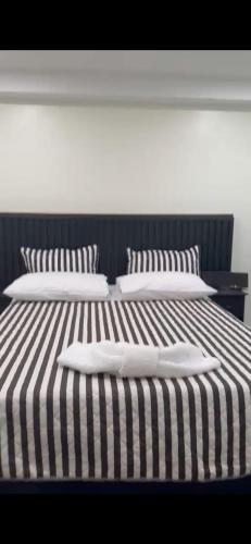 Duas almofadas brancas numa cama listrada a preto e branco em Lemmyalplace em Georgetown