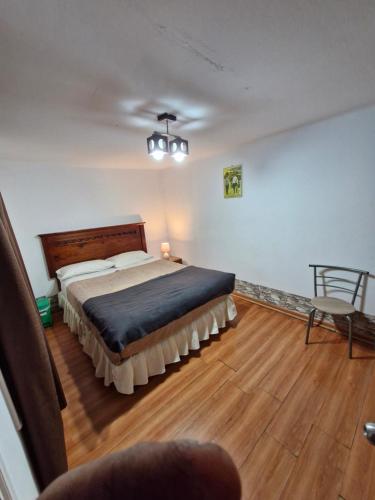 a bedroom with a large bed and a wooden floor at Hosteria Piedra Blanca in Taltal