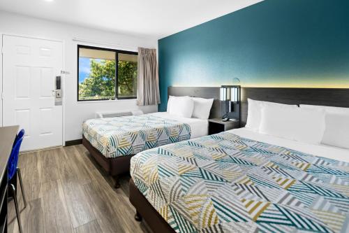 Cette chambre comprend 2 lits et une fenêtre. dans l'établissement Motel 6-Monterey, CA, à Monterey