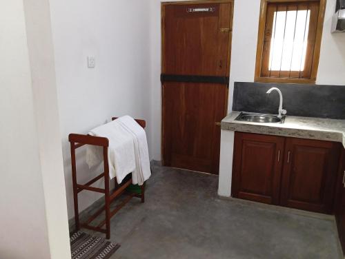 a kitchen with a sink and a towel on a chair at Villa 39 Katunayake Airport transit villa in Katunayake