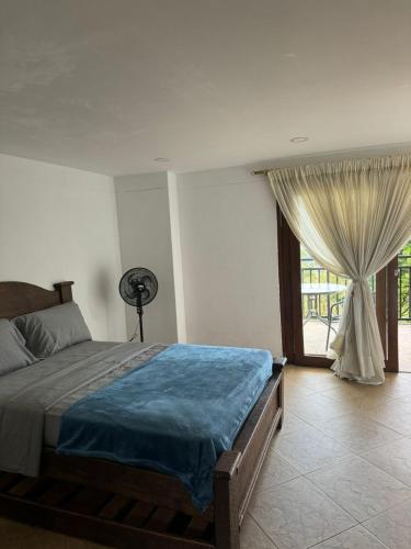 a bedroom with a bed and a large window at FINCA VILLA LORA GIRARDOTA in Girardota