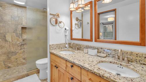 Un baño con dos lavabos, un inodoro y un espejo. en Mt View Lodge - Unit 21, en Sunriver