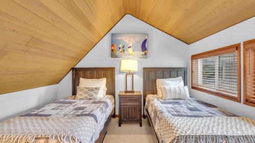 Dos camas en una habitación con techos de madera. en Mt View Lodge - Unit 21, en Sunriver