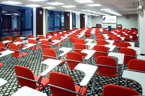 an empty room with red chairs and a podium at Central Hotel Sofia in Sofia