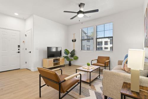 a living room with a couch and a tv at CozySuites Glendale by the stadium with pool 13 in Glendale