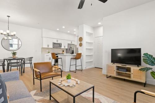 a living room with a couch and a tv at CozySuites Glendale by the stadium with pool 13 in Glendale