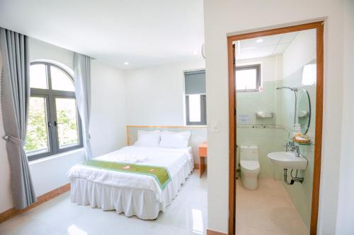 ALEX HOTEL AND SPA في An Bàn: غرفة نوم بسرير ومغسلة ومرحاض