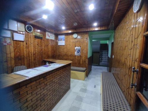 HOTEL UNIQUE في مانالي: بار في مطعم به جدران خشبية