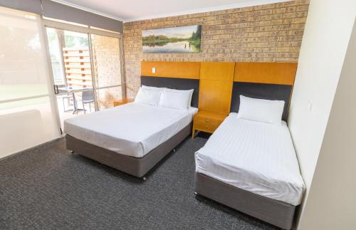 a room with two beds and a window at Sundowner Hotel Motel in Caboolture
