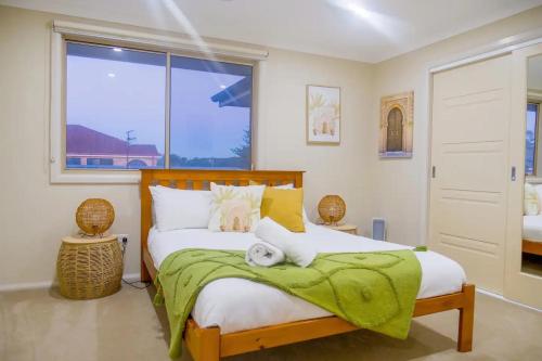 - une chambre avec un lit doté d'une couverture verte et d'une fenêtre dans l'établissement 6 Bedroom Beach & Lake Oasis, à Entrance