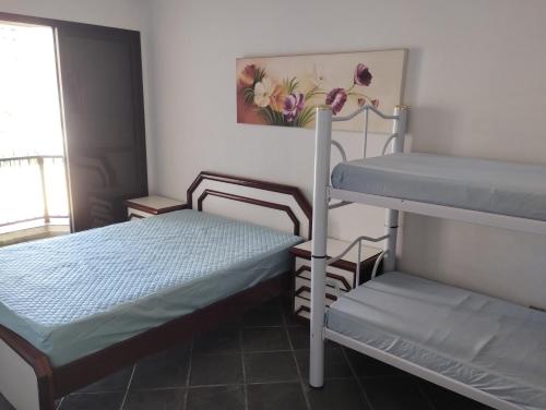 a small room with two bunk beds and a window at Apto Enseada Guarujá in Guarujá